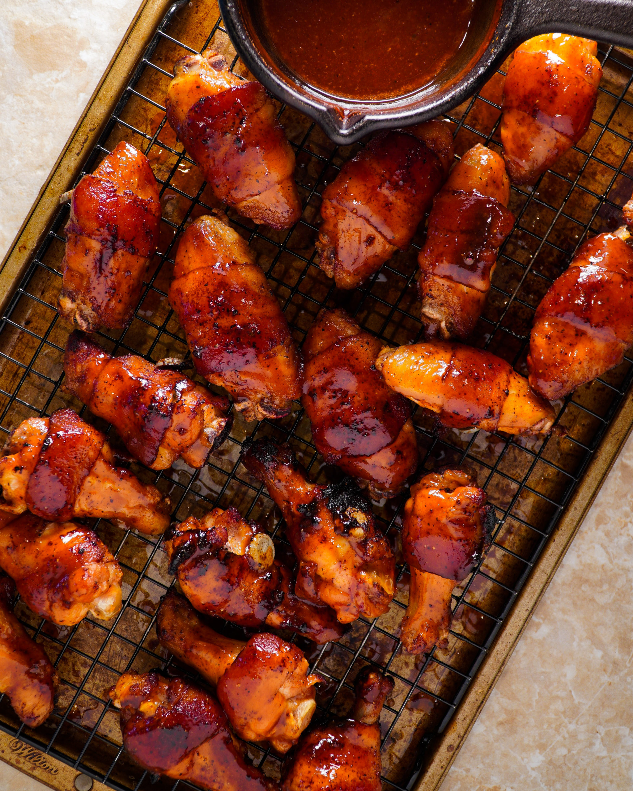 Alitas de pollo con tocino y bourbon bañadas en salsa BBQ.