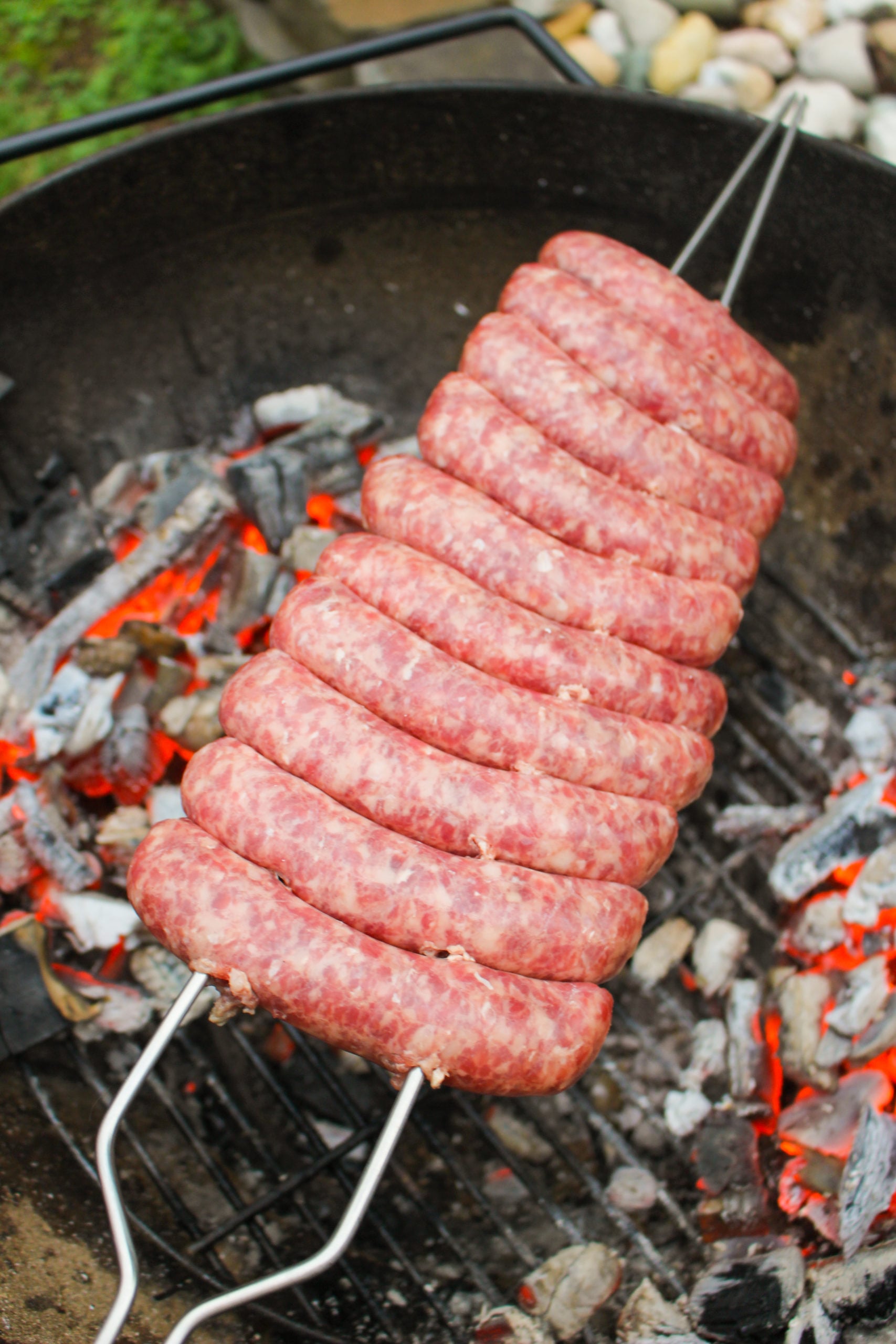 Brochetas de salchicha de queso de Filadelfia asando sobre el fuego.