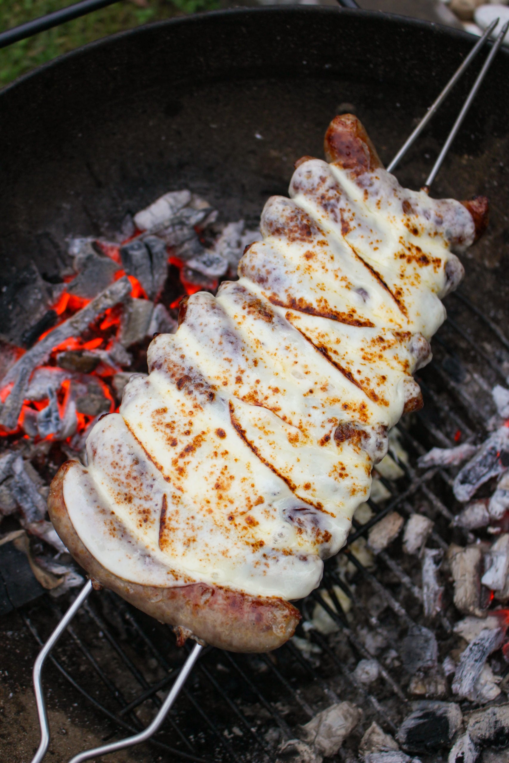 Brochetas de salchicha de queso Philly con queso encima.