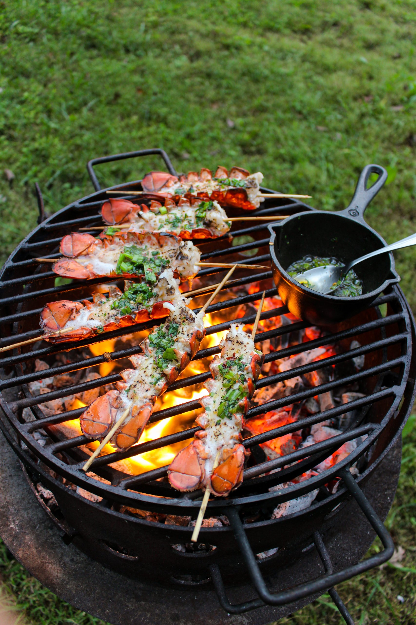 Brochetas de langosta con salsa Bang Bang bañadas con ghee de hierbas.